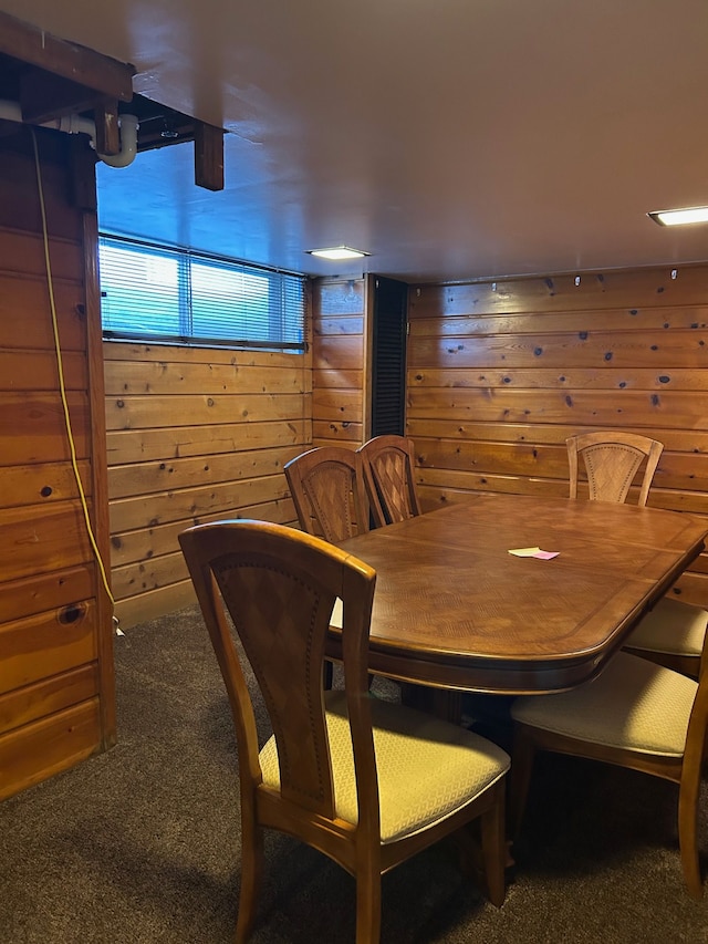 carpeted dining room with wood walls