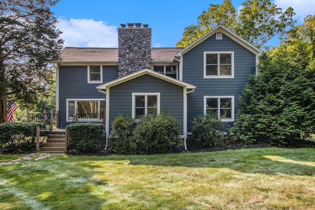 back of property with a wooden deck and a lawn