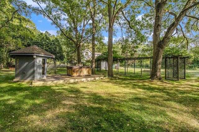 view of yard featuring a hot tub and a storage shed