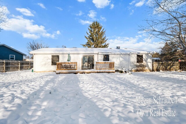 snow covered house featuring a wooden deck