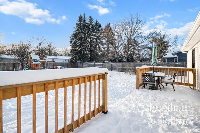 snow covered deck with a playground