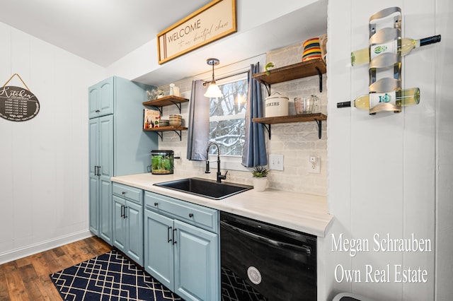 kitchen with blue cabinetry, dark wood-type flooring, sink, black dishwasher, and backsplash