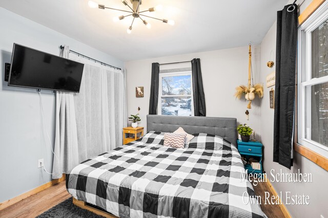 bedroom with a notable chandelier and hardwood / wood-style flooring