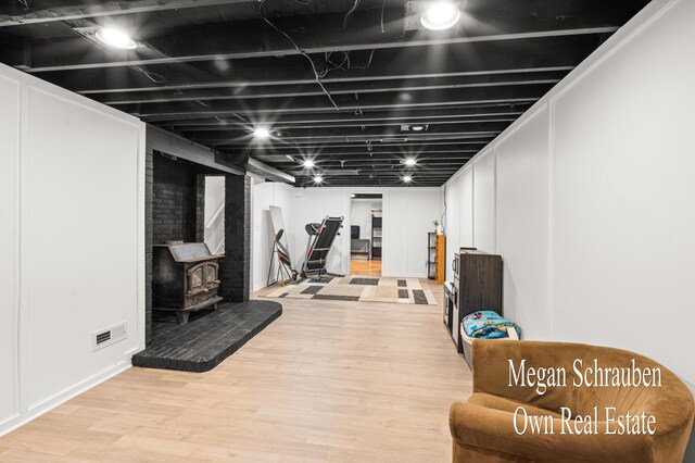 workout area with hardwood / wood-style flooring and a wood stove