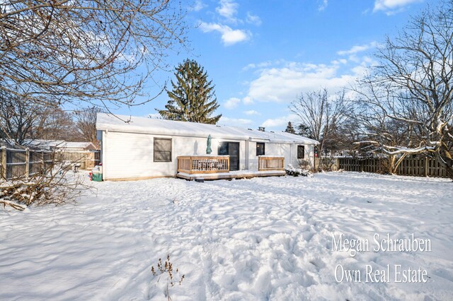 snow covered rear of property featuring a wooden deck