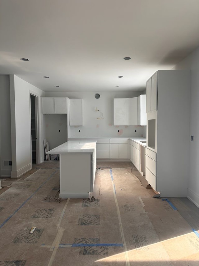 kitchen featuring a kitchen island and white cabinets