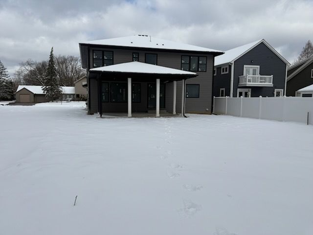 view of snow covered back of property