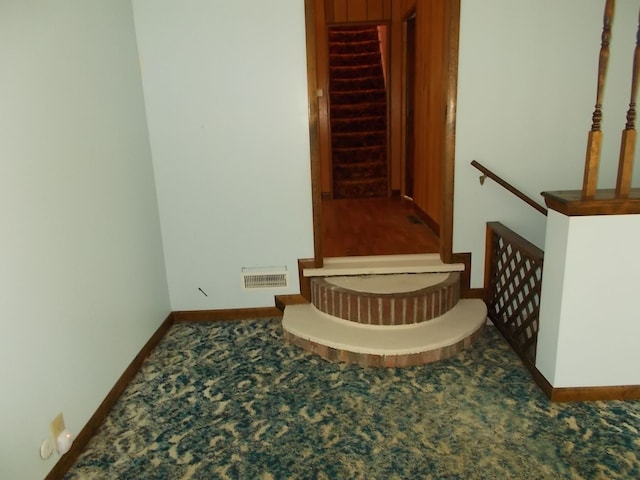 staircase featuring carpet