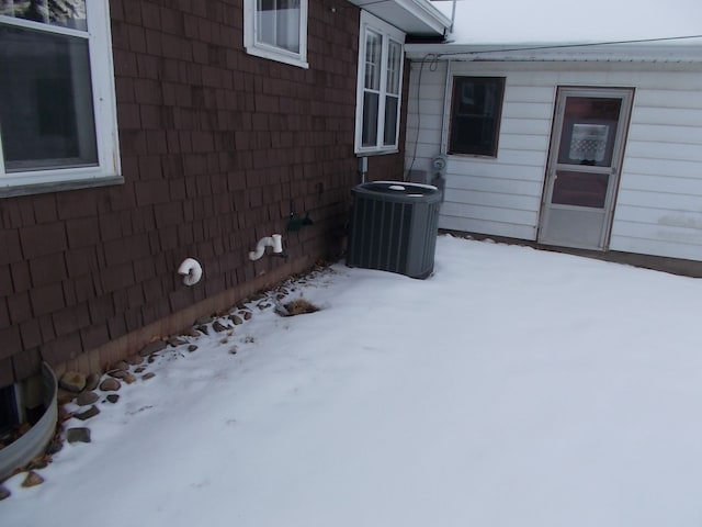 snow covered property featuring central air condition unit