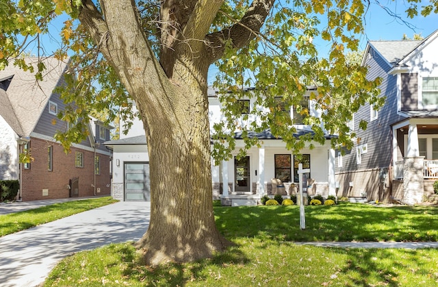 view of front of house with covered porch, a front yard, and a garage