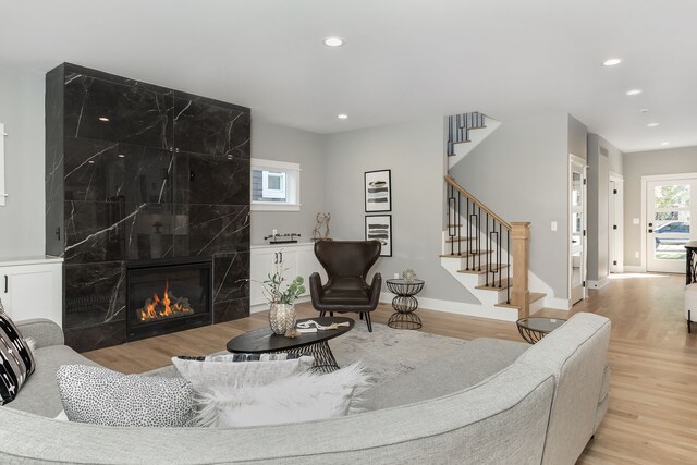 living room with light hardwood / wood-style floors and a high end fireplace