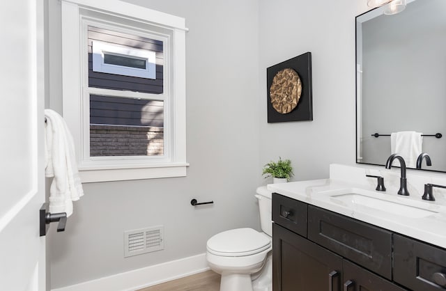 bathroom with hardwood / wood-style floors, vanity, and toilet