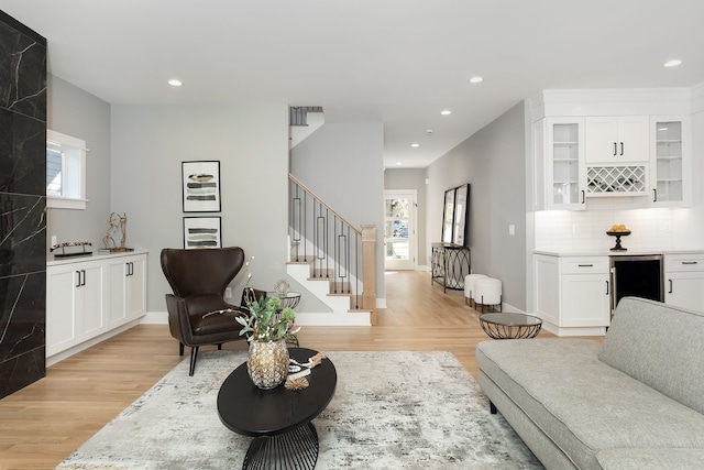 living room featuring light wood-type flooring, plenty of natural light, and wine cooler