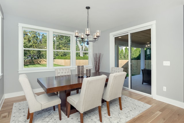 dining area with an inviting chandelier and light hardwood / wood-style floors