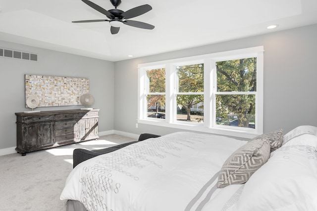 carpeted bedroom with ceiling fan and multiple windows