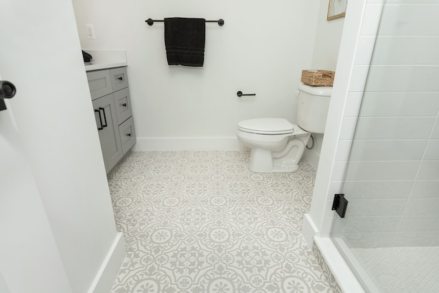 bathroom with tiled shower, tile patterned flooring, vanity, and toilet