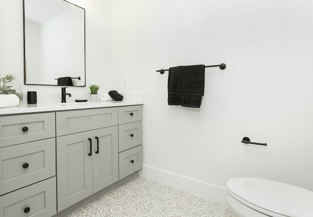 bathroom featuring tile patterned flooring, vanity, and toilet