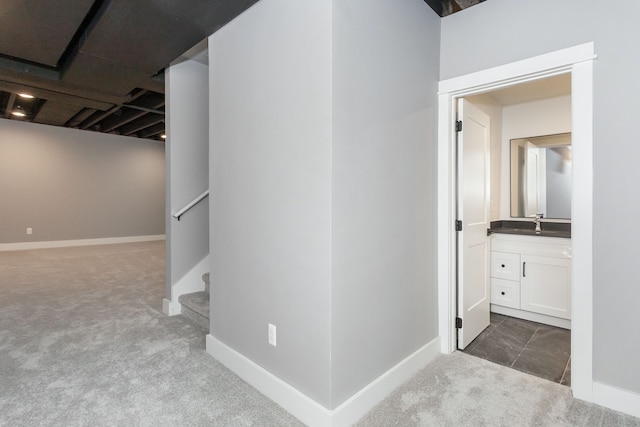 hallway with dark carpet and sink