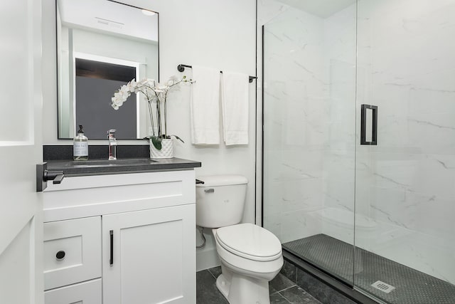 bathroom with toilet, vanity, and a shower with shower door