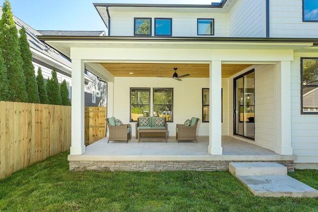 exterior space with a patio area, ceiling fan, a lawn, and an outdoor living space