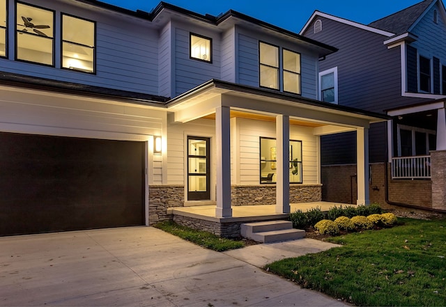 view of front of house featuring a porch, a front yard, and a garage