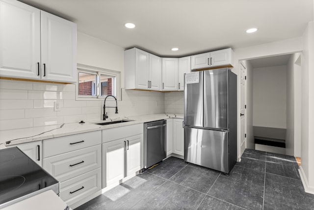 kitchen with light stone countertops, stainless steel appliances, decorative backsplash, white cabinets, and sink