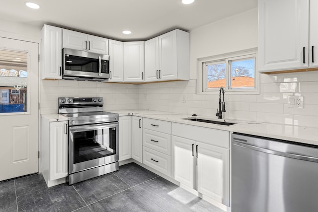 kitchen featuring sink, white cabinetry, light stone countertops, and appliances with stainless steel finishes