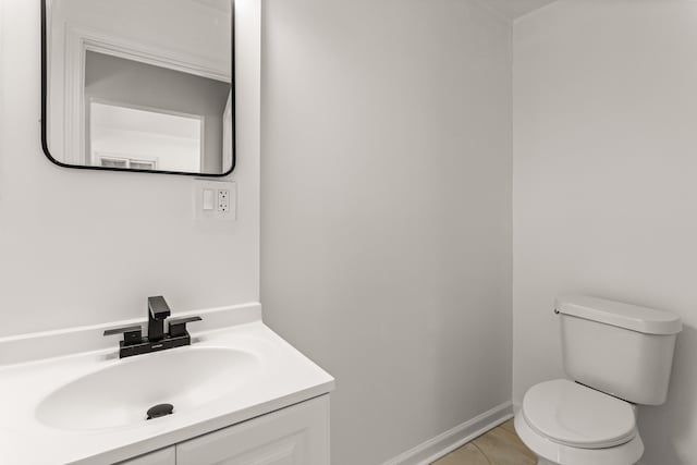 bathroom with toilet, tile patterned floors, and vanity