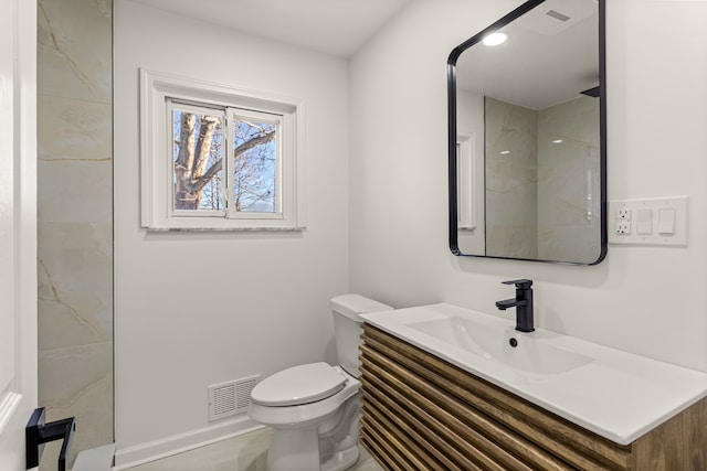 bathroom featuring toilet, vanity, and walk in shower