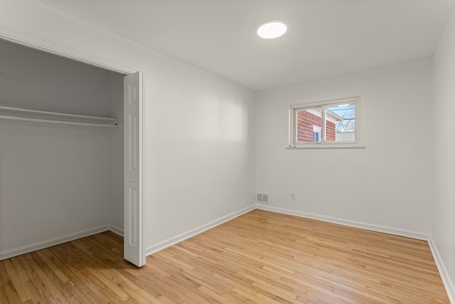 unfurnished bedroom featuring light hardwood / wood-style floors and a closet