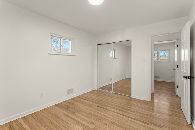 unfurnished bedroom featuring a closet and light hardwood / wood-style flooring