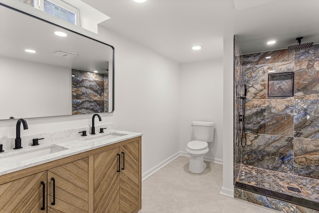 bathroom featuring toilet, a tile shower, and vanity