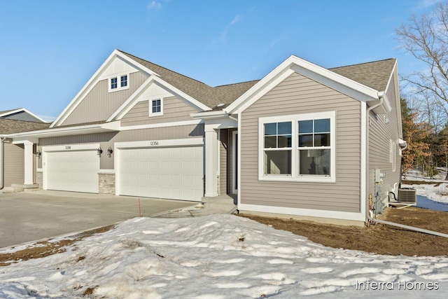 view of front of property featuring a garage and cooling unit