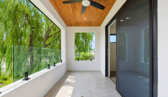 unfurnished sunroom featuring ceiling fan and wood ceiling