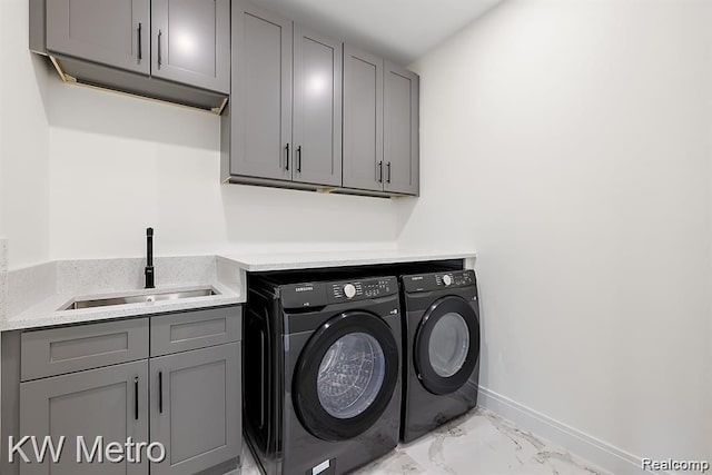 laundry room with cabinets, separate washer and dryer, and sink