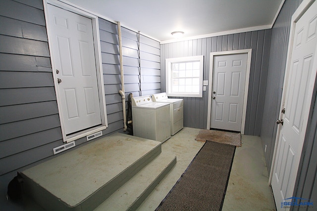 laundry area featuring washing machine and dryer and wood walls