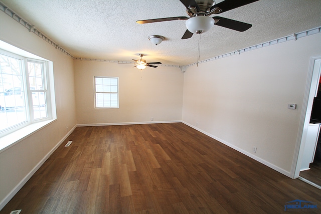 spare room featuring dark wood-type flooring, a textured ceiling, and ceiling fan