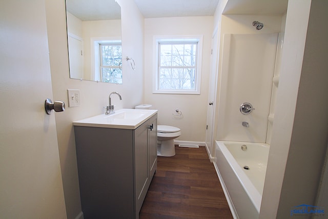 full bathroom with hardwood / wood-style floors, toilet, tub / shower combination, and vanity