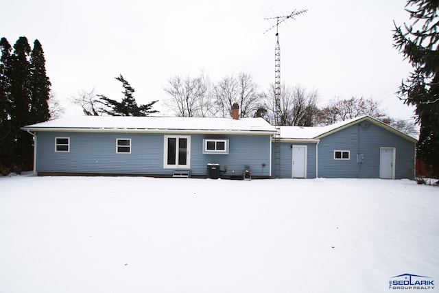 view of snow covered rear of property