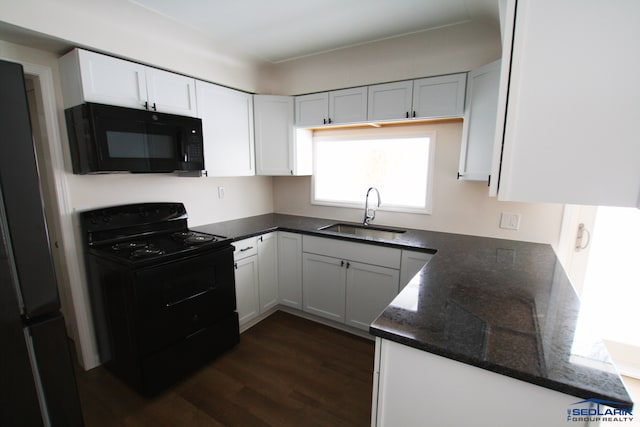 kitchen featuring black appliances, dark hardwood / wood-style flooring, white cabinetry, dark stone counters, and sink