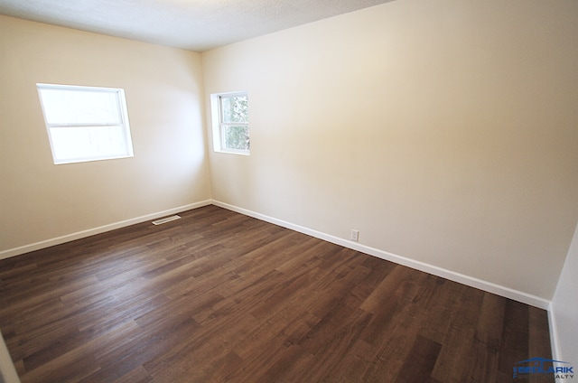 unfurnished room with dark hardwood / wood-style floors