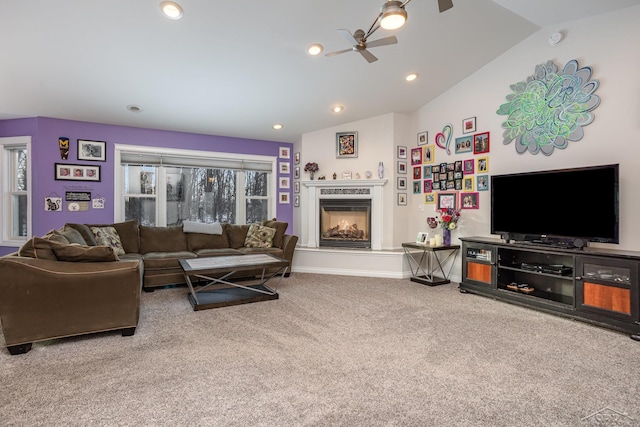 carpeted living room featuring lofted ceiling, a premium fireplace, and ceiling fan