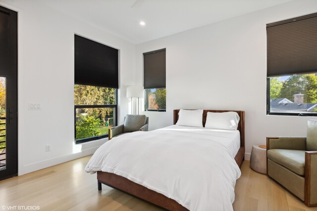 bedroom with multiple windows and light hardwood / wood-style flooring