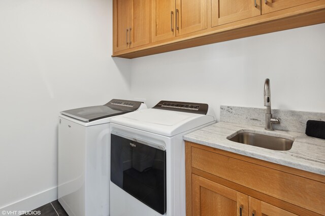 laundry area featuring cabinets, tile patterned flooring, washer and dryer, and sink