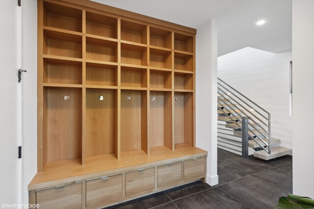 mudroom with dark tile patterned floors