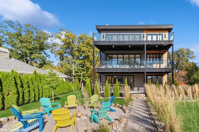 rear view of property with a patio and a fire pit