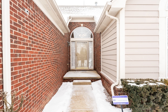 doorway to property featuring brick siding