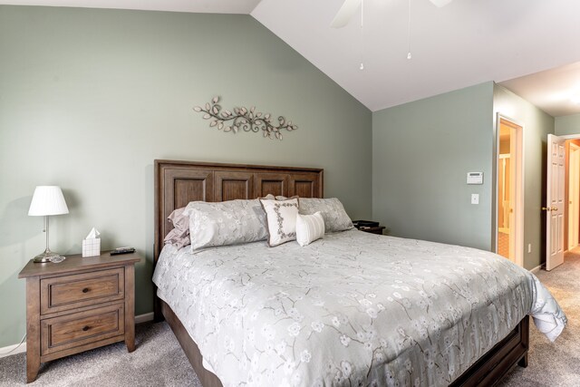 bedroom with ceiling fan, connected bathroom, light carpet, and lofted ceiling