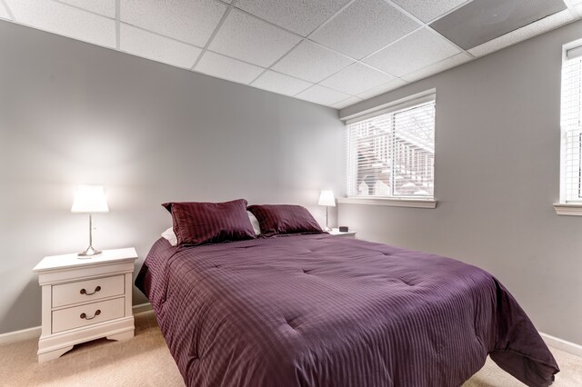 carpeted bedroom with a drop ceiling