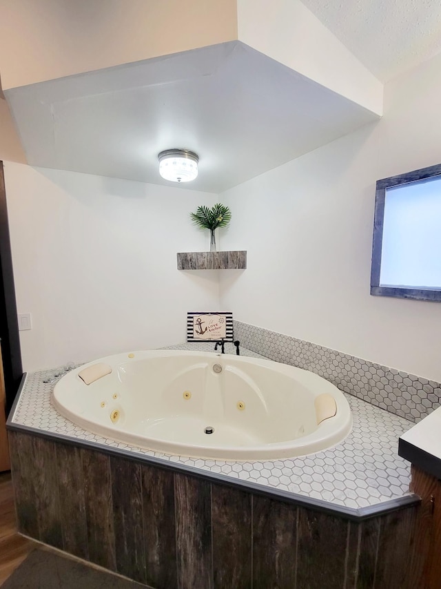 bathroom with wood-type flooring and a relaxing tiled tub